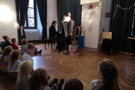 Foto zeigt Peter Grauer, der vor einem Kinder-Publikum spielt