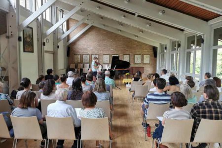 Foto von Schülervorspiel 17.06.2023 zeigt einen Jugen, der vor Publikum Violine spielt