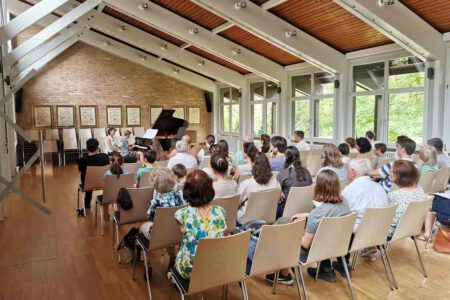 Foto von Schülervorspiel 17.06.2023 zeigt einen Jugen, der vor Publikum Klavier spielt